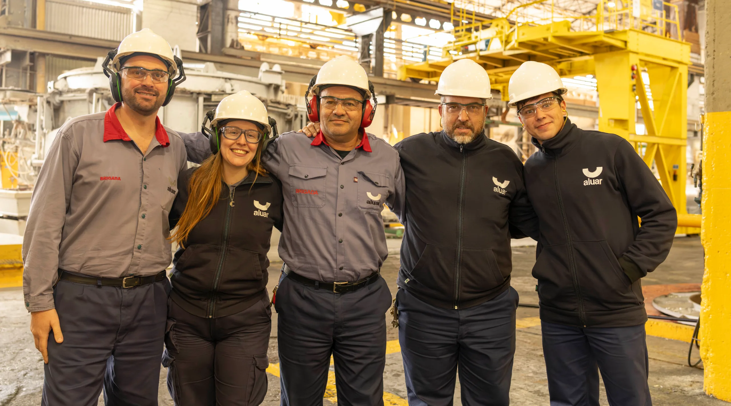 Equipo de planta de Aluar con cascos y ropa de trabajo